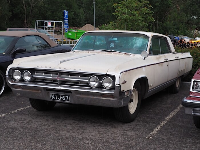 Valkoinen 1964 Oldsmobile Ninety-Eight 4d Sedan Suomi-auto. Kuvan tekijä: Kai Lappalainen. Lisenssi: CC-BY-40.