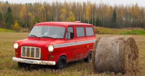 Punainen 1975 Ford Transit heinäpellolla