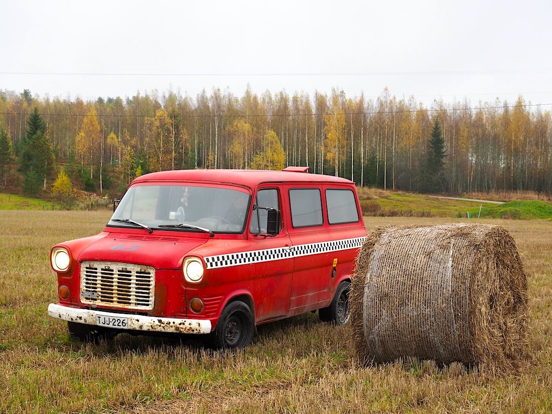 Punainen 1975 Ford Transit heinäpellolla