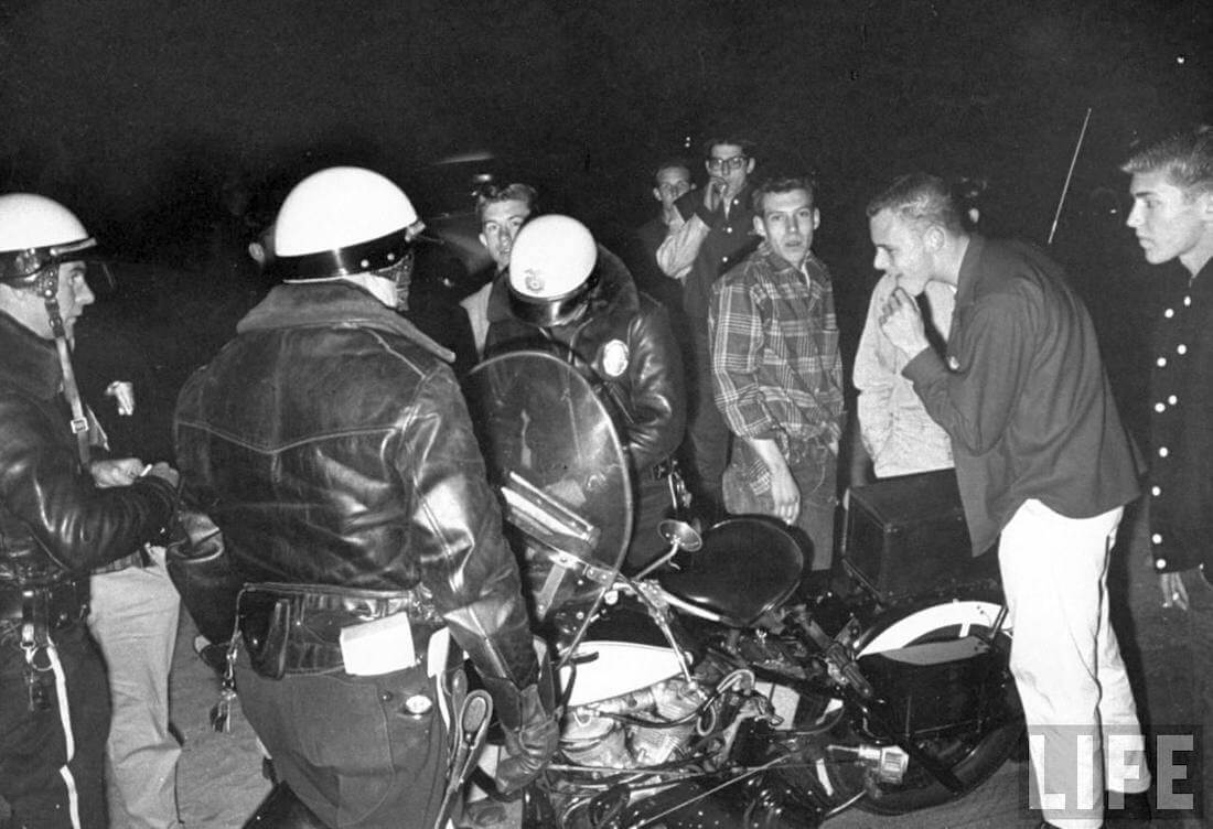 Poliisi sakottaa laittomiin kiihdytyskilpailuihin osallistuneita nuoria vuonna 1957.