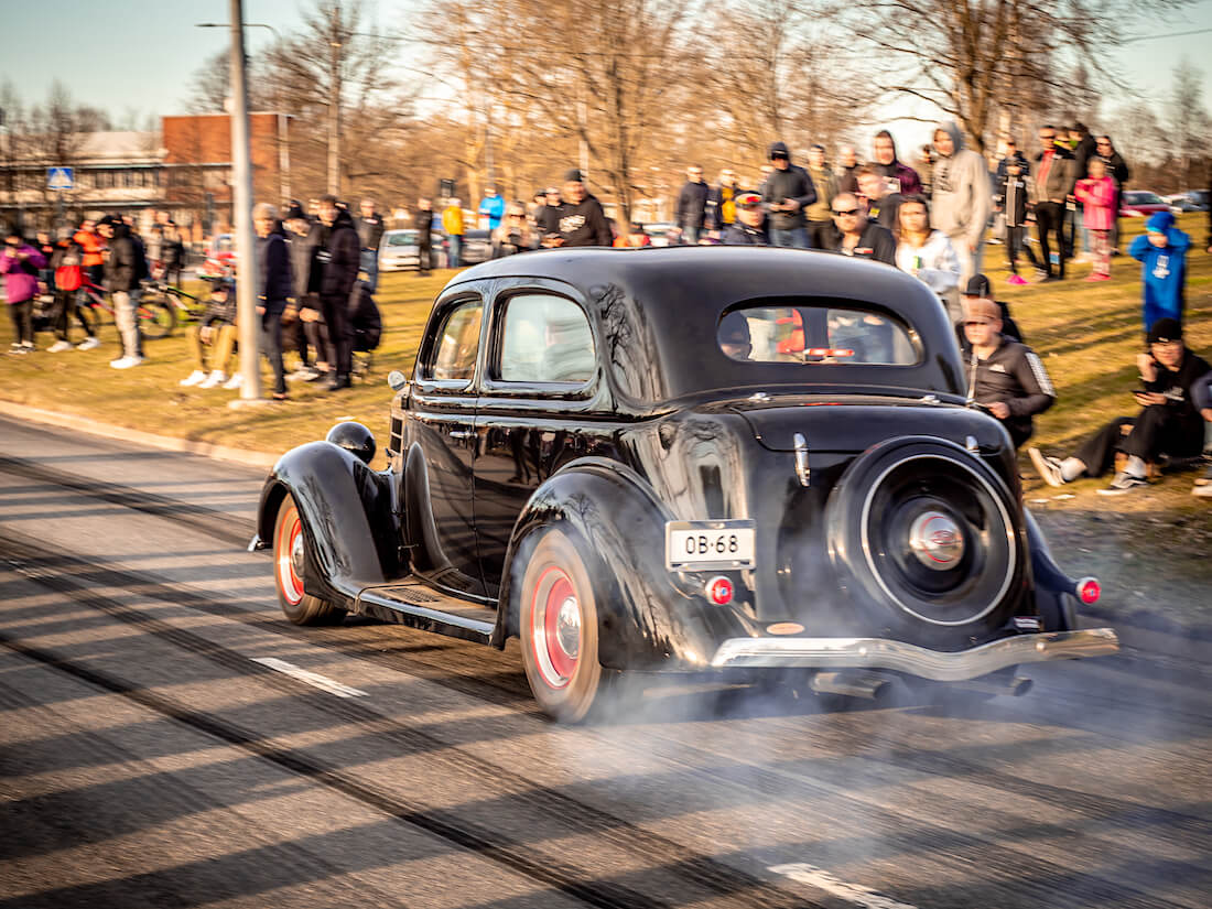 Musta 1936 Ford Tudor jenkkiauto kiihdyttää