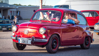 Nuoria miehiä pienessä Fiat 600 autossa