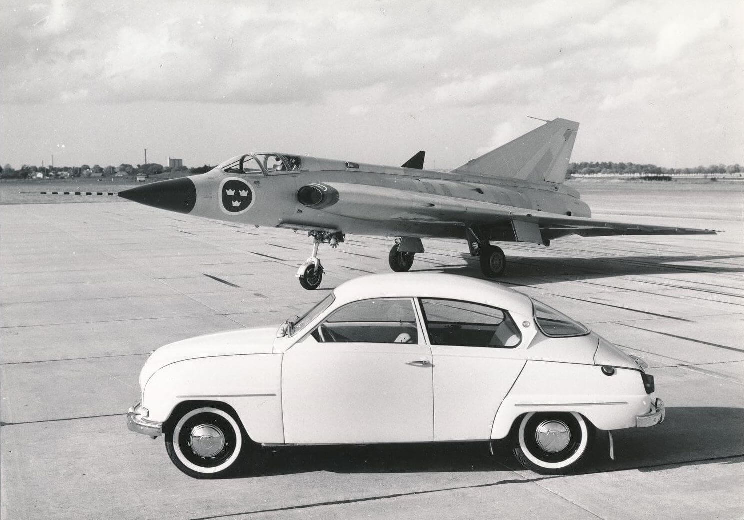 Saan 96 auto Saab Draken hävittäjälentokoneen edessä. Kuva: Saab